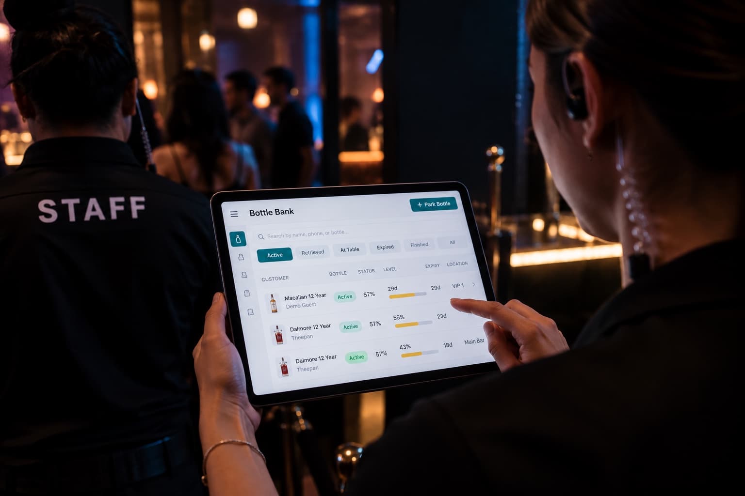 Illustrative image: staff holding the iPad on a venue floor at night
